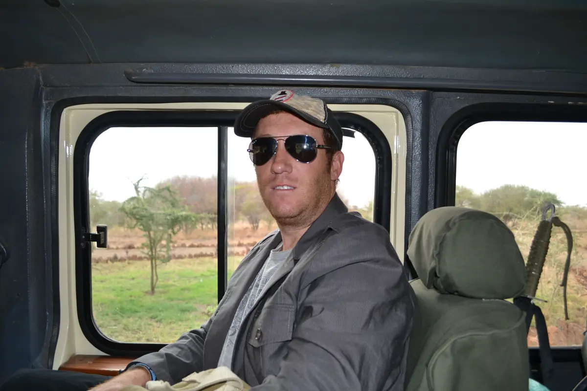 A traveler in sunglasses in the seat of a safari Land Cruiser